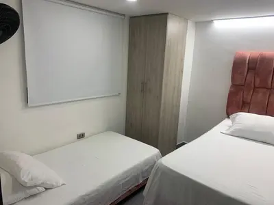 two beds in a small room with a mirror at hermoso y nuevo apartamento en laureles in Medellín
