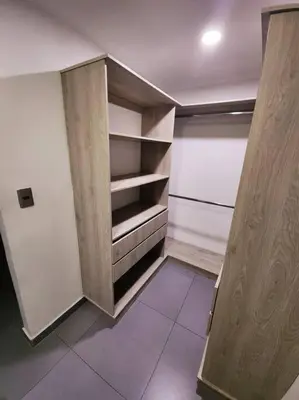 an empty closet with wooden shelves in a room at hermoso y nuevo apartamento en laureles in Medellín