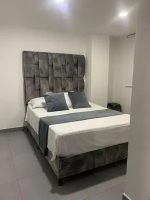 a large bed with a large headboard in a bedroom at hermoso y nuevo apartamento en laureles in Medellín
