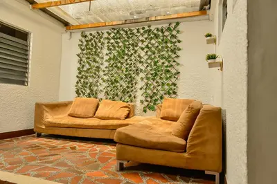 a living room with a couch and a chair at hostal casa prado in in Medellín