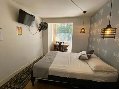 a bedroom with a bed and a tv on the wall at hostal casa prado in in Medellín