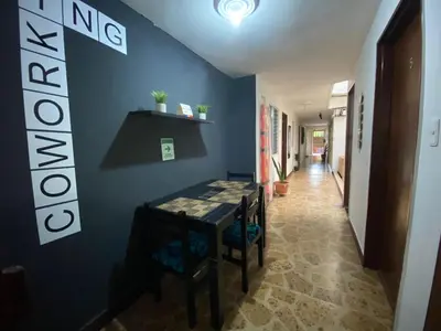 a dining room with a blue wall and a table and chairs at hostal casa prado in in Medellín