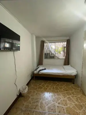 a small room with a bed and a window at hostal casa prado in in Medellín
