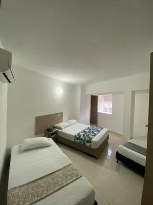 a hotel room with two beds in a room at Hotel Suites 44 Laureles in Medellín