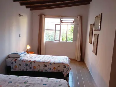 a bedroom with two beds and a window at Casa zona Laureles in Medellín