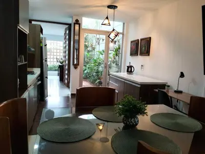 a kitchen and dining room with a table and chairs at Vivenzza in Jardin
