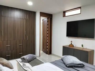 a bedroom with a bed and a flat screen tv at Vivenzza in Jardin