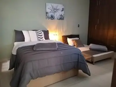 a bedroom with a large bed and a couch at Vivenzza in Jardin