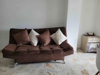 a brown couch with pillows on it in a living room at Apartamento acogedor barrio la Floresta Medellín in Medellín