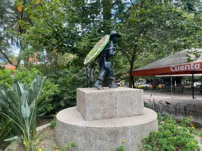 a statue of a man with a surfboard on his back at Apartamento acogedor barrio la Floresta Medellín in Medellín