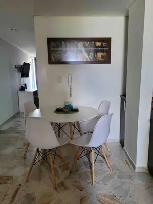 a dining room with a white table and chairs at Apartamento acogedor barrio la Floresta Medellín in Medellín