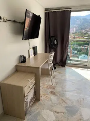 a room with a desk and a window with a view at Apartamento acogedor barrio la Floresta Medellín in Medellín