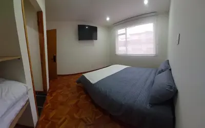 a small bedroom with a bed and a window at Casa Palermo Manizales in Manizales