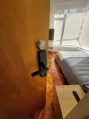 a bedroom with a bed and a door with a lamp at Casa Palermo Manizales in Manizales