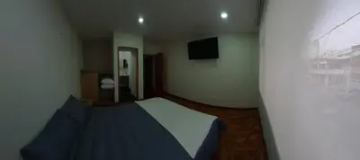 a small bedroom with a bed and a television at Casa Palermo Manizales in Manizales