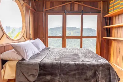 a bed in a room with a large window at Finca La Arabia Jardín in Jardin