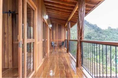 an empty porch of a wooden house with a balcony at Finca La Arabia Jardín in Jardin