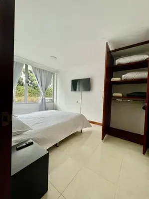 a bedroom with a bed and a tv and a window at Milano Manizales in Manizales