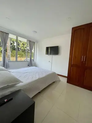 a bedroom with a bed and a television in it at Milano Manizales in Manizales