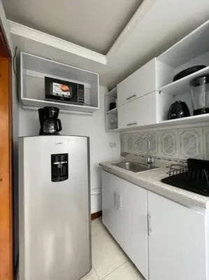 a white kitchen with a sink and a refrigerator at Milano Manizales in Manizales