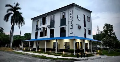 a large white building with a clock on it at Hotel ZT in Mariquita