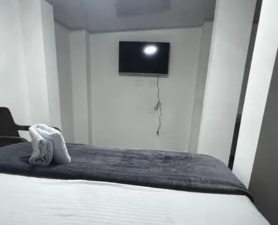 a bedroom with a bed with a tv on the wall at Hotel ZT in Mariquita