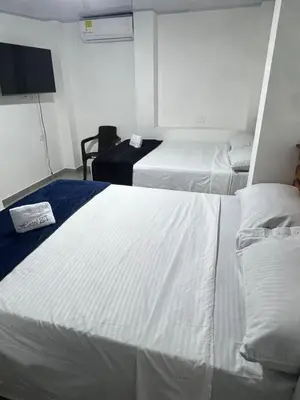 a hotel room with two beds and a flat screen tv at Hotel ZT in Mariquita