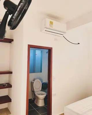 a bathroom with a toilet and a air conditioner on the ceiling at Hotel ZT in Mariquita