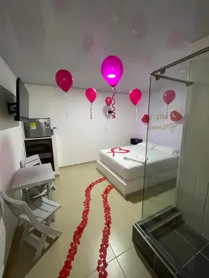 a room with pink balloons on the wall and a bed at Hotel ZT in Mariquita