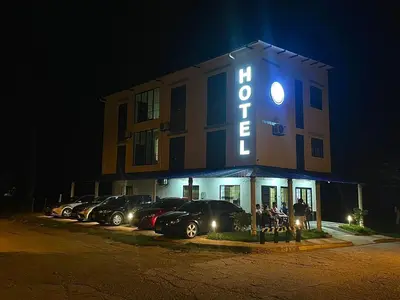 a hotel with cars parked in a parking lot at night at Hotel ZT in Mariquita
