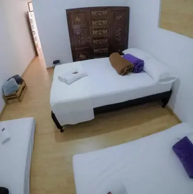 a bed in a room with two white beds at Casa Hotel Piedra del Sol in Betania