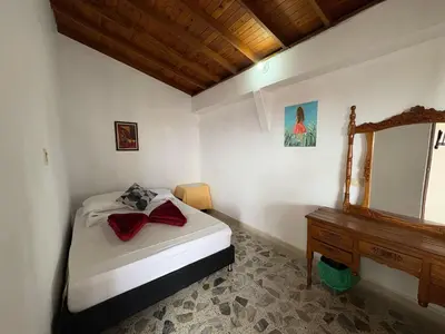 a bedroom with a bed and a dresser and a mirror at Casa Hotel Piedra del Sol in Betania