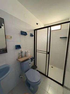a bathroom with a blue toilet and a shower at Casa Hotel Piedra del Sol in Betania
