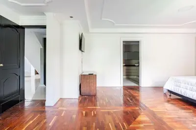 a living room with a bed and a wooden floor at 3 Story Penthouse with 2 parking spaces in Laureles in Medellín