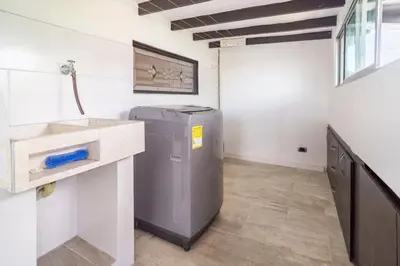 a laundry room with a washing machine and a sink at 3 Story Penthouse with 2 parking spaces in Laureles in Medellín