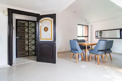 a dining room with a table and chairs and a door at 3 Story Penthouse with 2 parking spaces in Laureles in Medellín