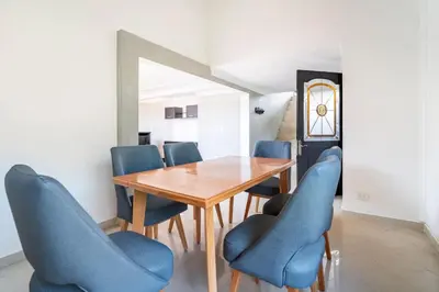a dining room with a wooden table and blue chairs at 3 Story Penthouse with 2 parking spaces in Laureles in Medellín