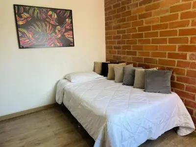 a bed in a room with a brick wall at Impecable y lujoso apartamento para una estadía unica in Medellín