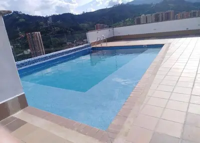 a large blue swimming pool on top of a building at Impecable y lujoso apartamento para una estadía unica in Medellín