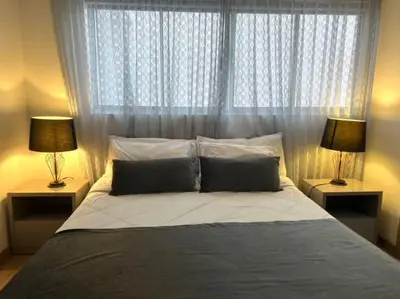 a bedroom with a large bed with two lamps at Impecable y lujoso apartamento para una estadía unica in Medellín