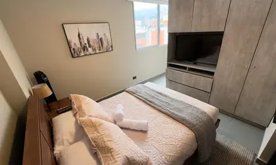 a small room with a bed with a television and a bed sidx sidx sidx at Apartment near Provenza by Hoost in Medellín