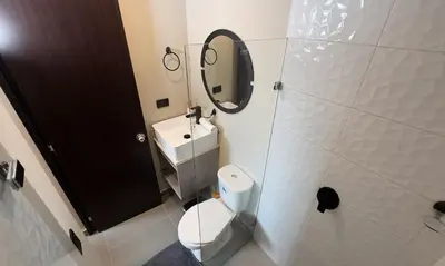 a bathroom with a toilet and a sink and a mirror at Apartment near Provenza by Hoost in Medellín