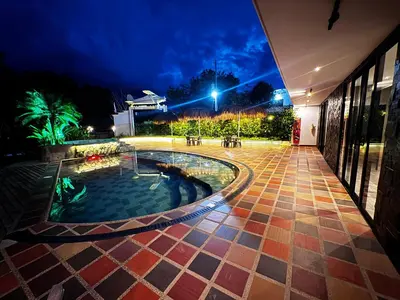 a pool in the middle of a courtyard at night at Finca La Casa de Pablo in Doradal