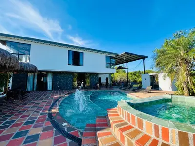 a swimming pool in front of a house at Finca La Casa de Pablo in Doradal