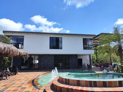 a house with a fountain in front of a building at Finca La Casa de Pablo in Doradal