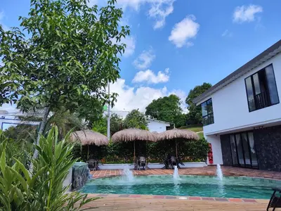 a swimming pool with umbrellas and chairs at Finca La Casa de Pablo in Doradal
