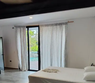 a bedroom with a bed and a sliding glass door at Finca La Casa de Pablo in Doradal