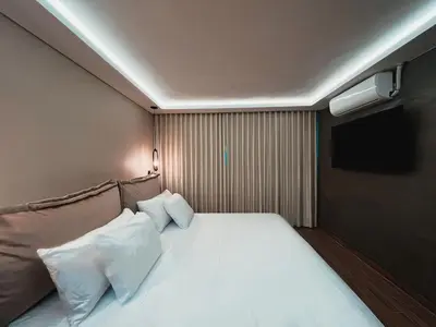 a bedroom with a bed with two pillows and a television at LUXURY PALACE POBLADO MANILA in El Poblado