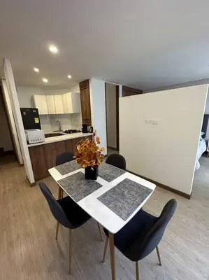 a dining room with a table and chairs and a kitchen at Loft moderno en zona exclusiva in Manizales