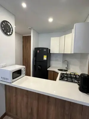 a kitchen with a microwave and a black refrigerator at Loft moderno en zona exclusiva in Manizales